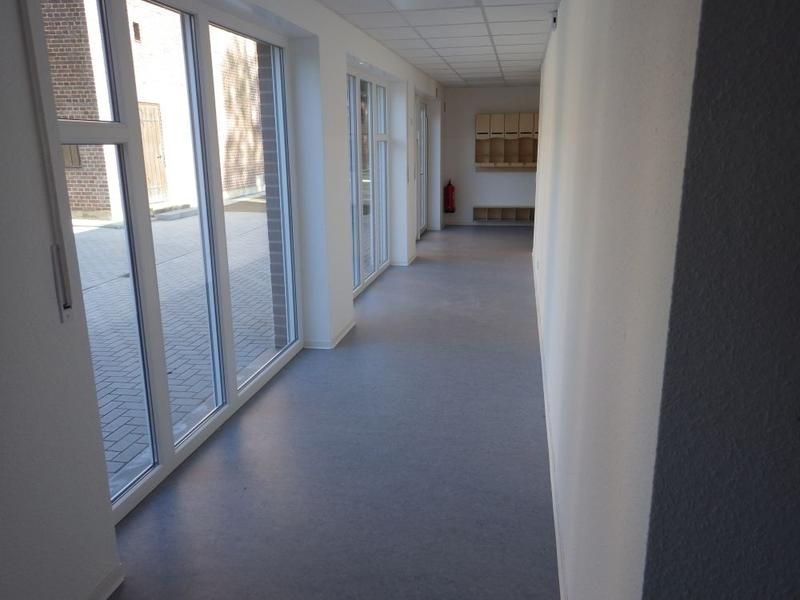 Ein langer Flur mit vielen Fenstern und Türen