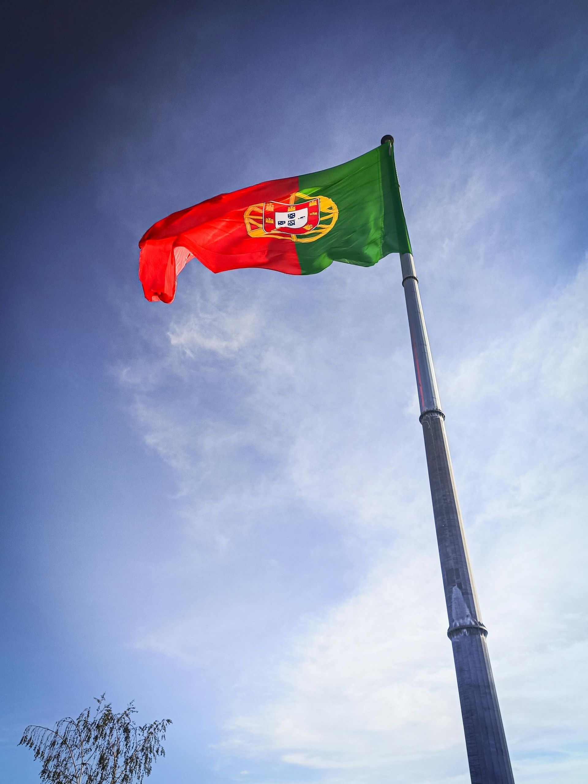 Uma bandeira vermelha e verde está tremulando ao vento