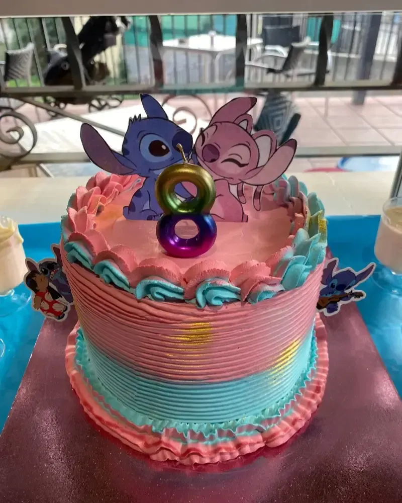 Variedad de pasteles y porciones de pastel sobre una tabla de madera en una cocina, incluyendo coberturas de chocolate.