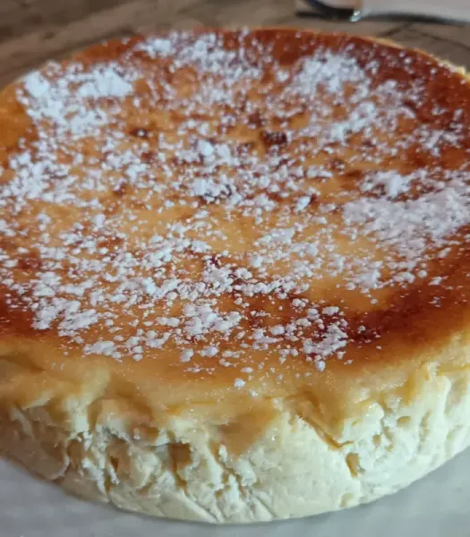 Variedad de pasteles y porciones de pastel sobre una tabla de madera en una cocina, incluyendo coberturas de chocolate.