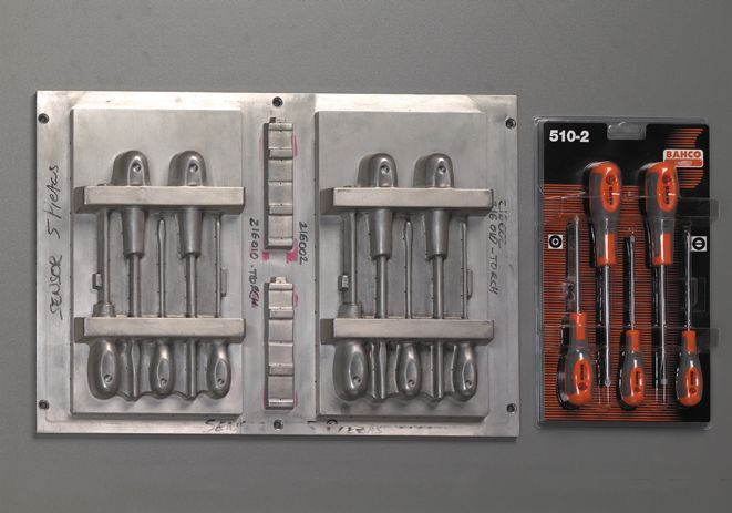 Un juego de destornilladores se encuentra junto a un molde de destornillador.