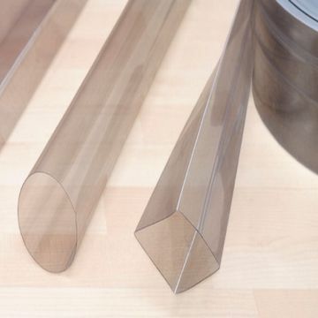 Tres tubos de plástico transparente están sobre una mesa de madera al lado de un rollo de cinta.