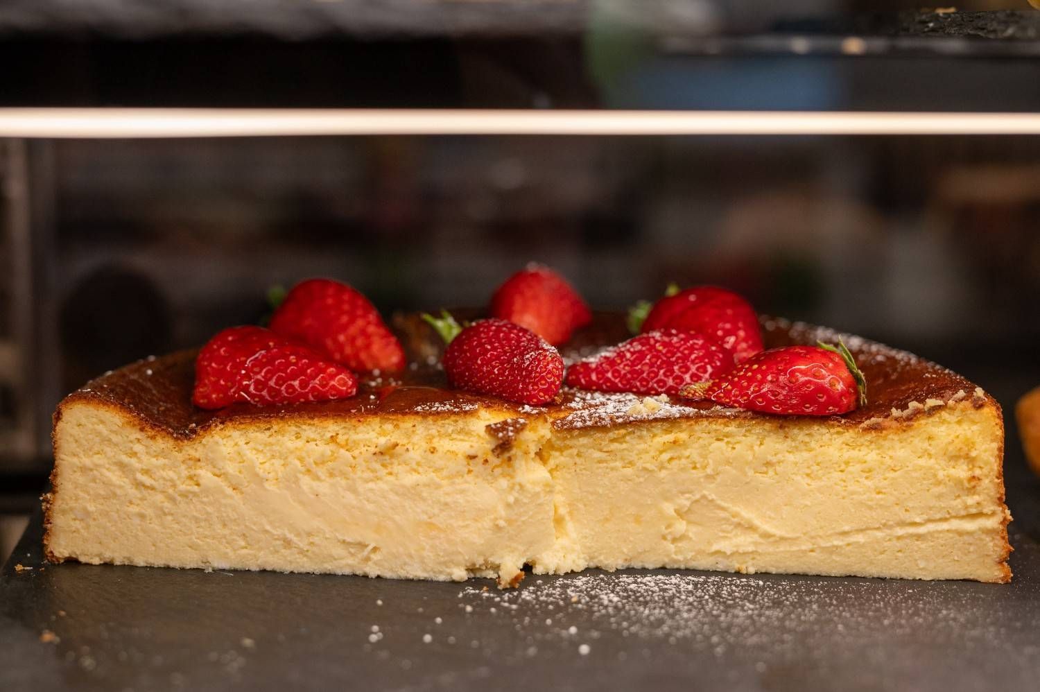 Una porción de tarta de queso cubierta con fresas en una bandeja para hornear en el horno.