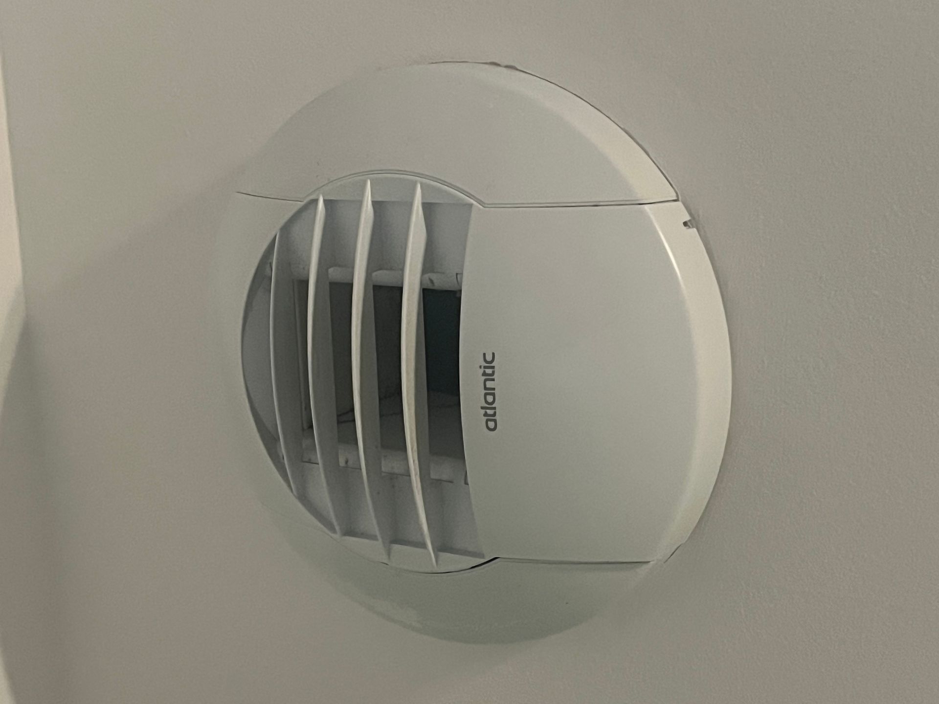 Grille d'aération murale blanche Atlantic à lamelles inclinées.