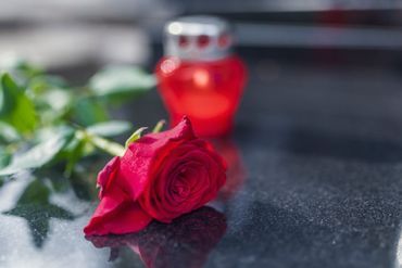Punainen ruusu ja hautakynttilä