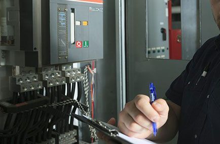 Un technicien rédigeait des documents dans la zone du panneau de commande d'une usine, à côté de machines industrielles.