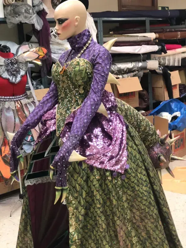 Maniquí con traje detallado verde y morado, probablemente para una producción teatral.