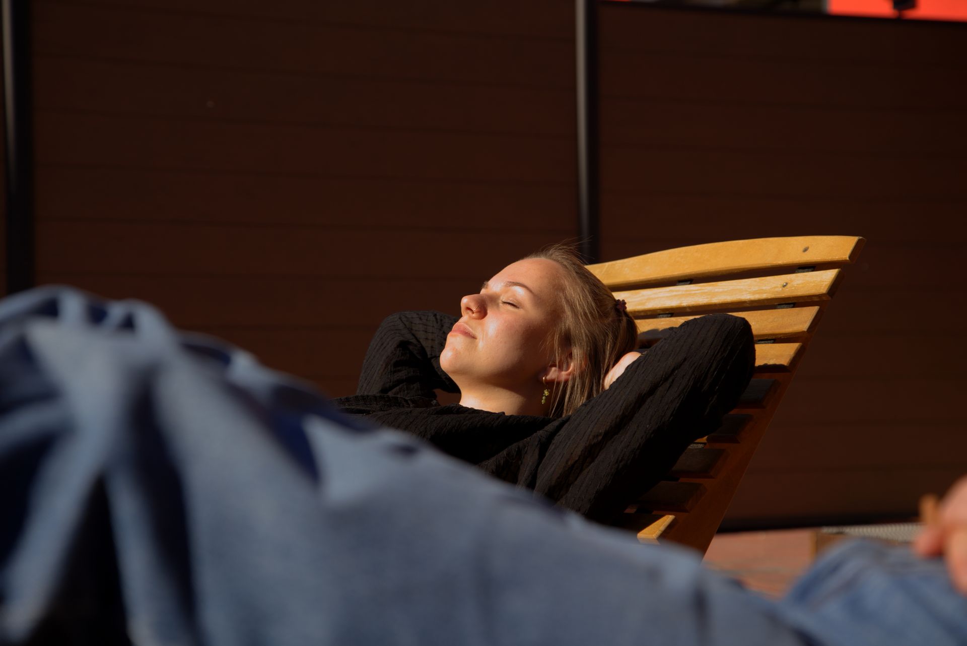 Bild Gästin entspannt auf der Liege vor der Sauna in der Sonne
