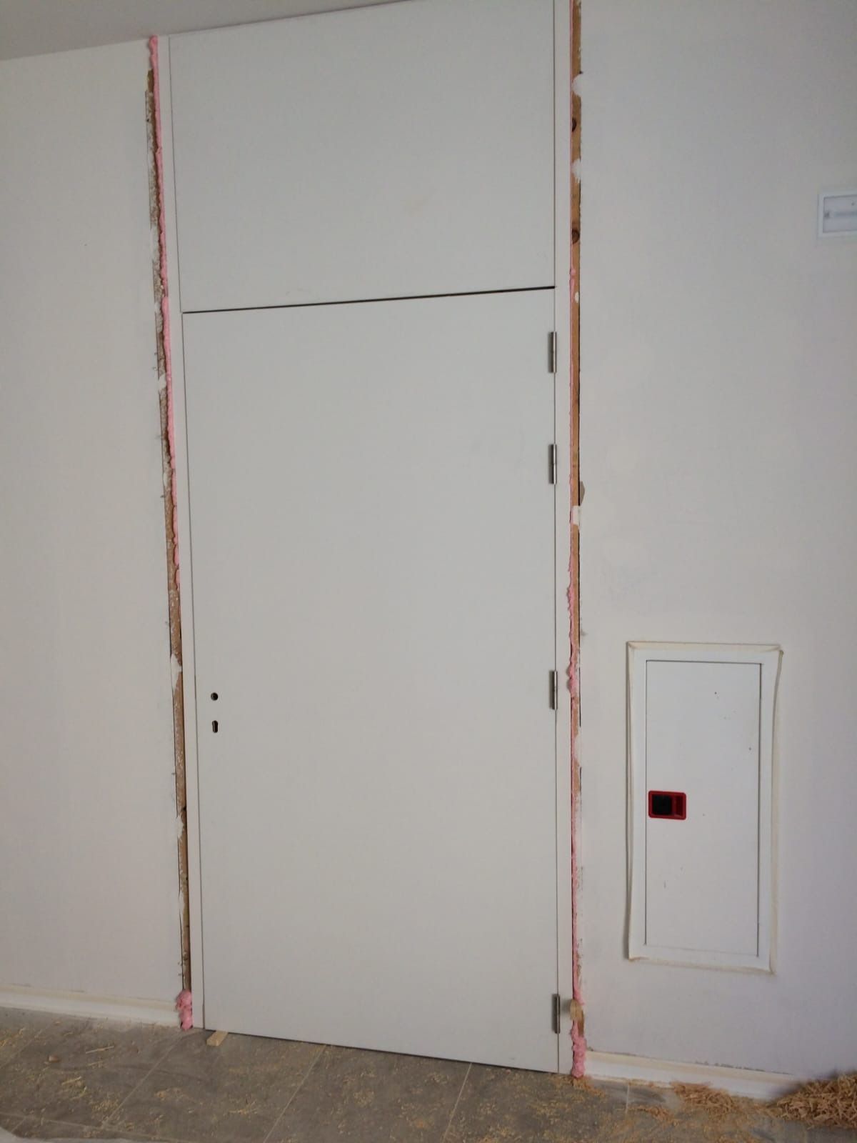 Una puerta blanca y un panel a 