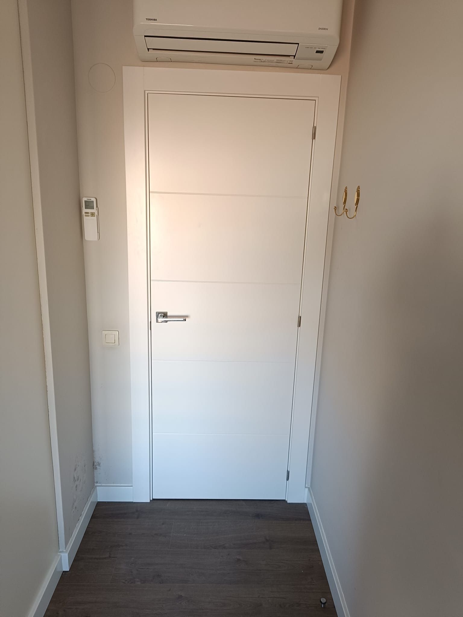 Una puerta interior blanca con paneles horizontales en un 