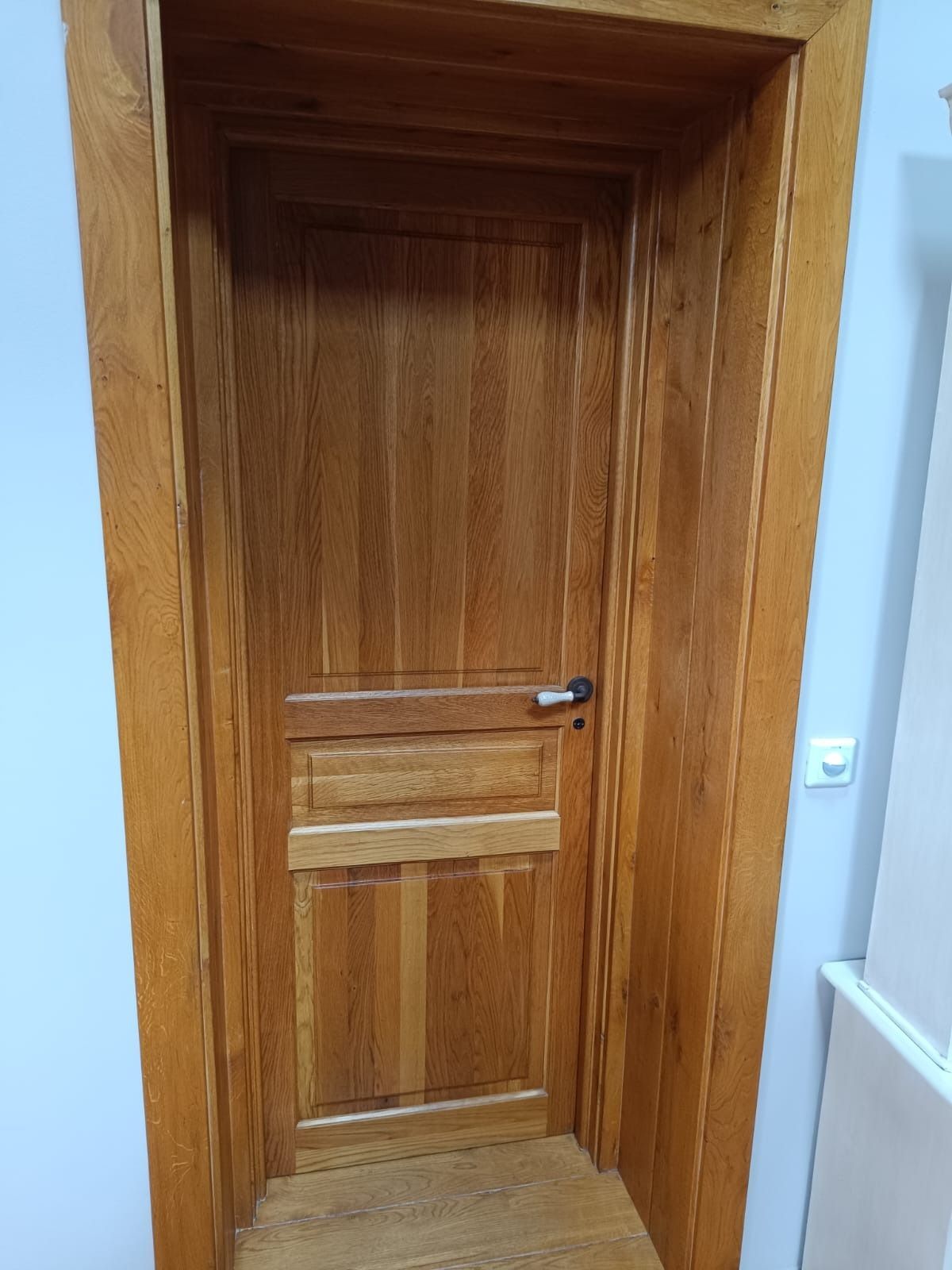 Una puerta de madera de tono medio con diseño de paneles 