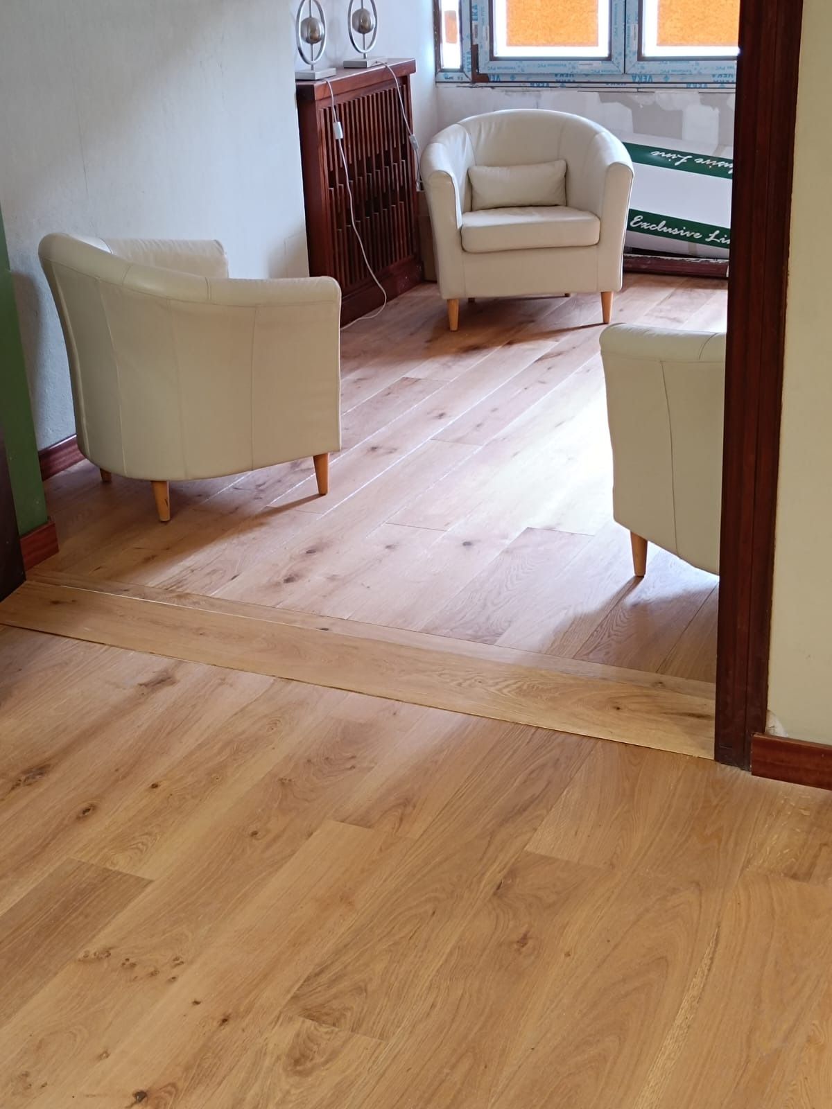 Tres sillones de color claro dispuestos en una habitación con suelo de madera clara.