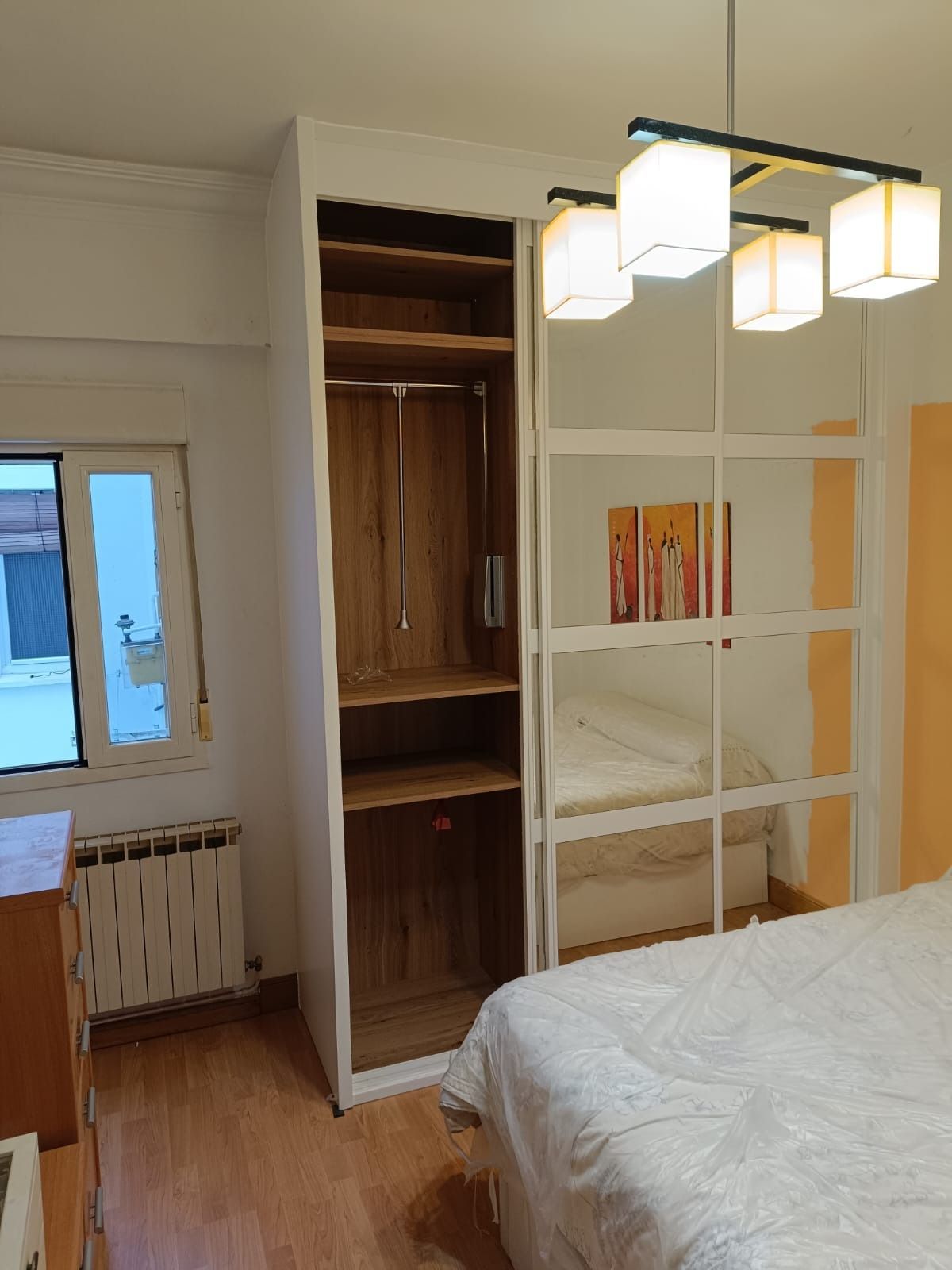 Un dormitorio con un armario alto 