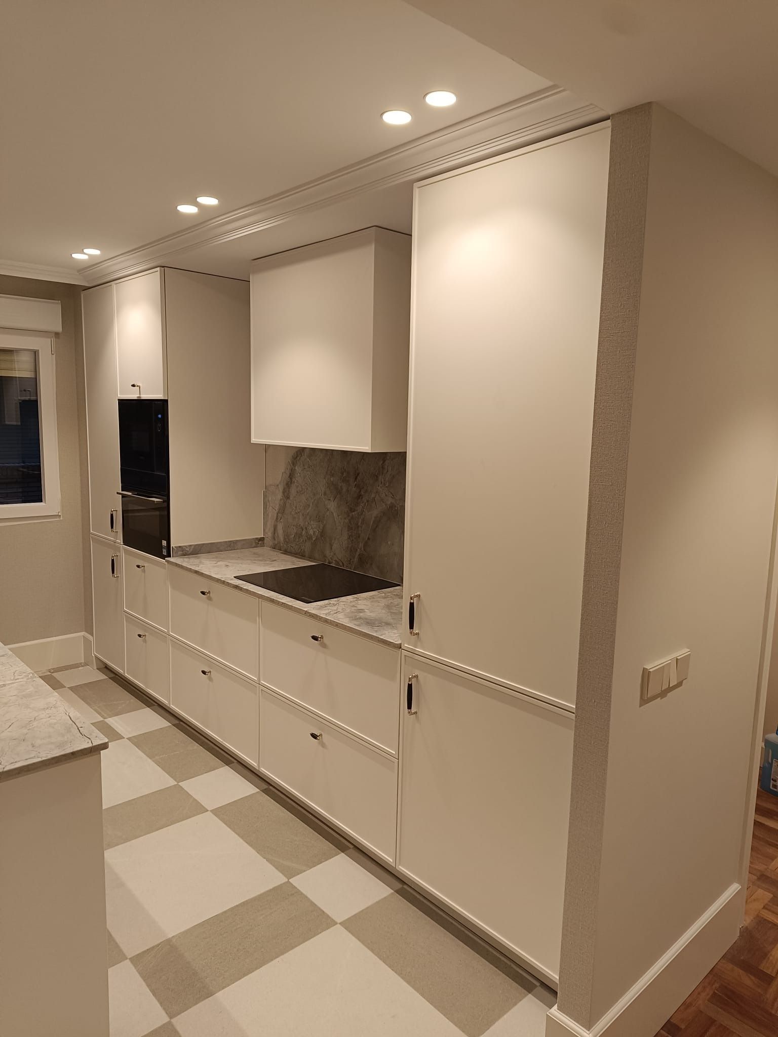 Una cocina moderna cuenta congabinetes blancos, un h