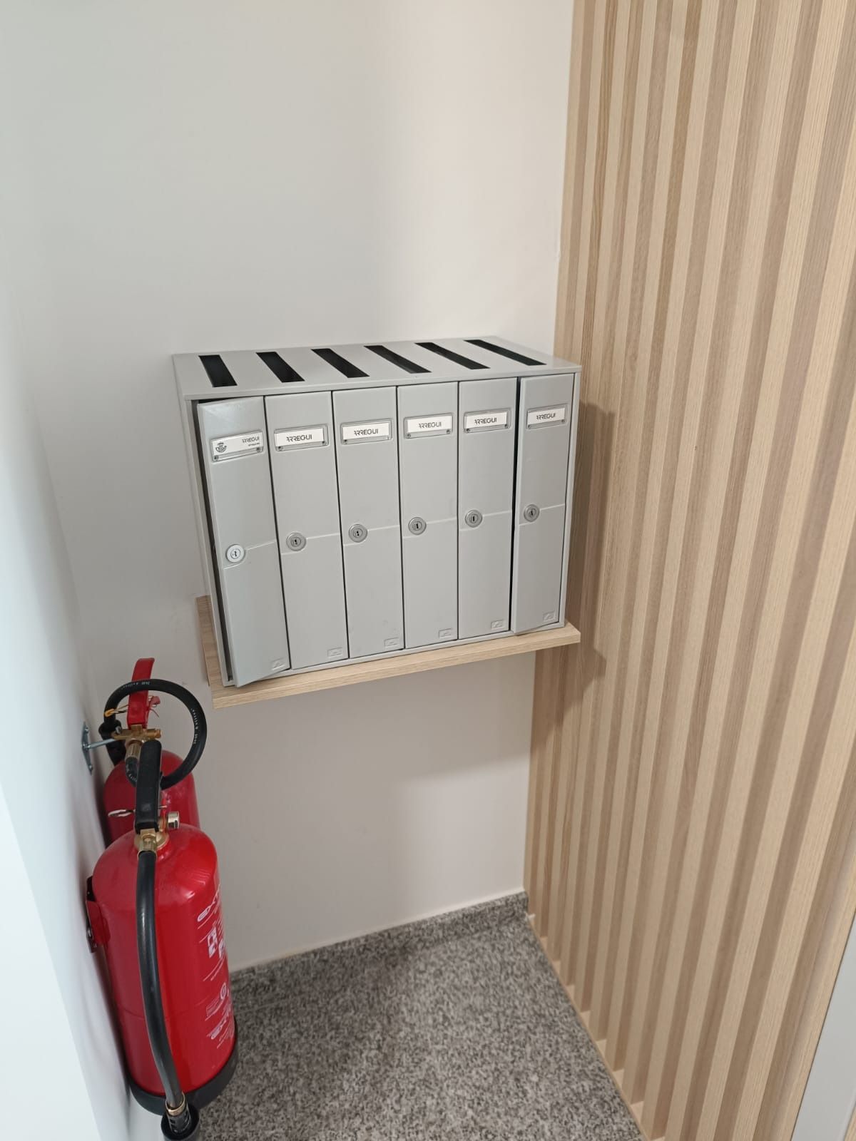 Seis archivadores plateados se extintor rojo, en un rincón interior.