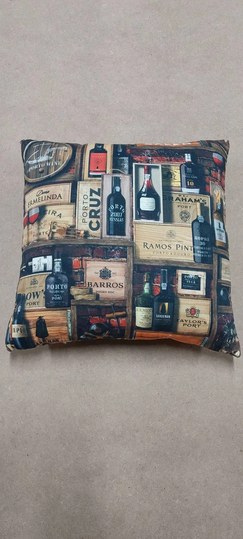 Um travesseiro com garrafas de vinho sobre ele está sobre uma mesa.