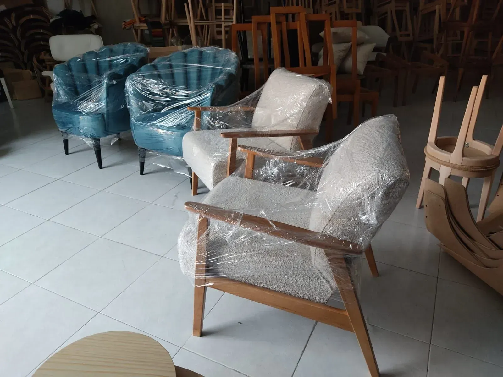 Uma espreguiçadeira bege com duas almofadas sobre uma superfície branca.