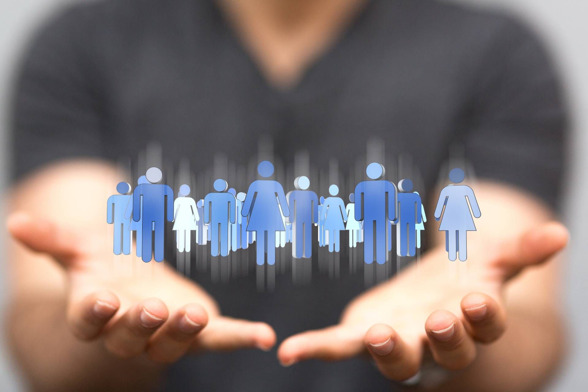 Eine Person hält viele Männchen-Icons in den Händen