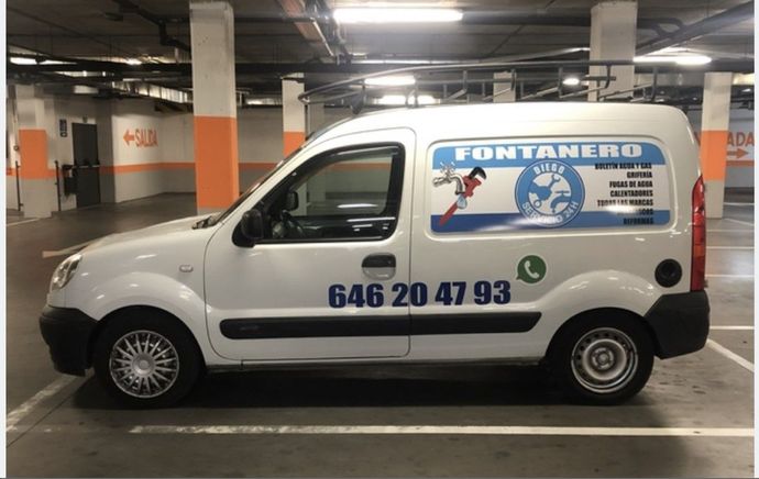 Una furgoneta blanca está estacionada en un aparcamiento.