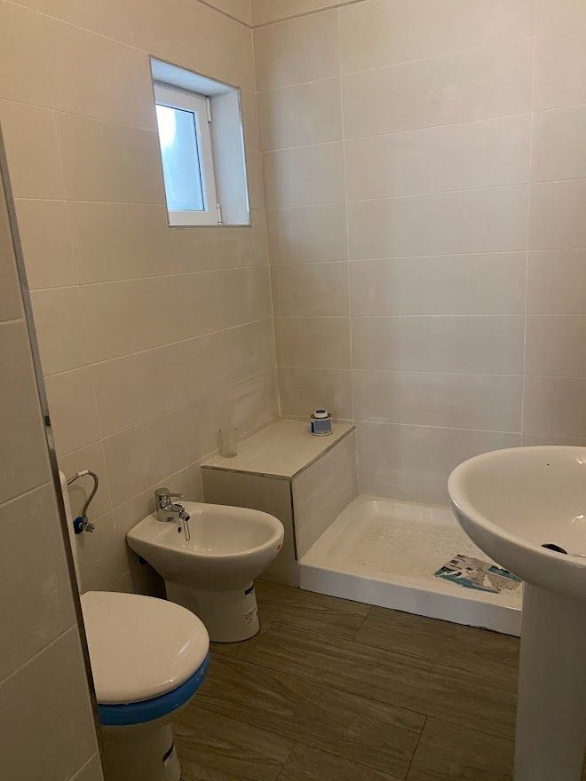 Un baño con inodoro, lavabo y ducha.