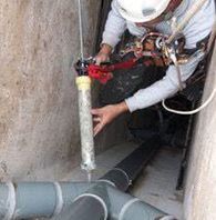 Un hombre está trabajando en una tubería en un túnel.