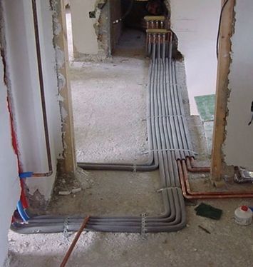 Un pasillo con un montón de tuberías que lo atraviesan.