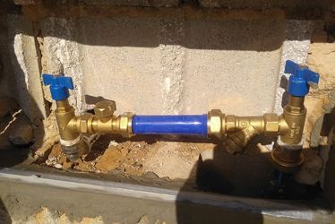 Un primer plano de un tubo de latón con una manguera azul unida a él.