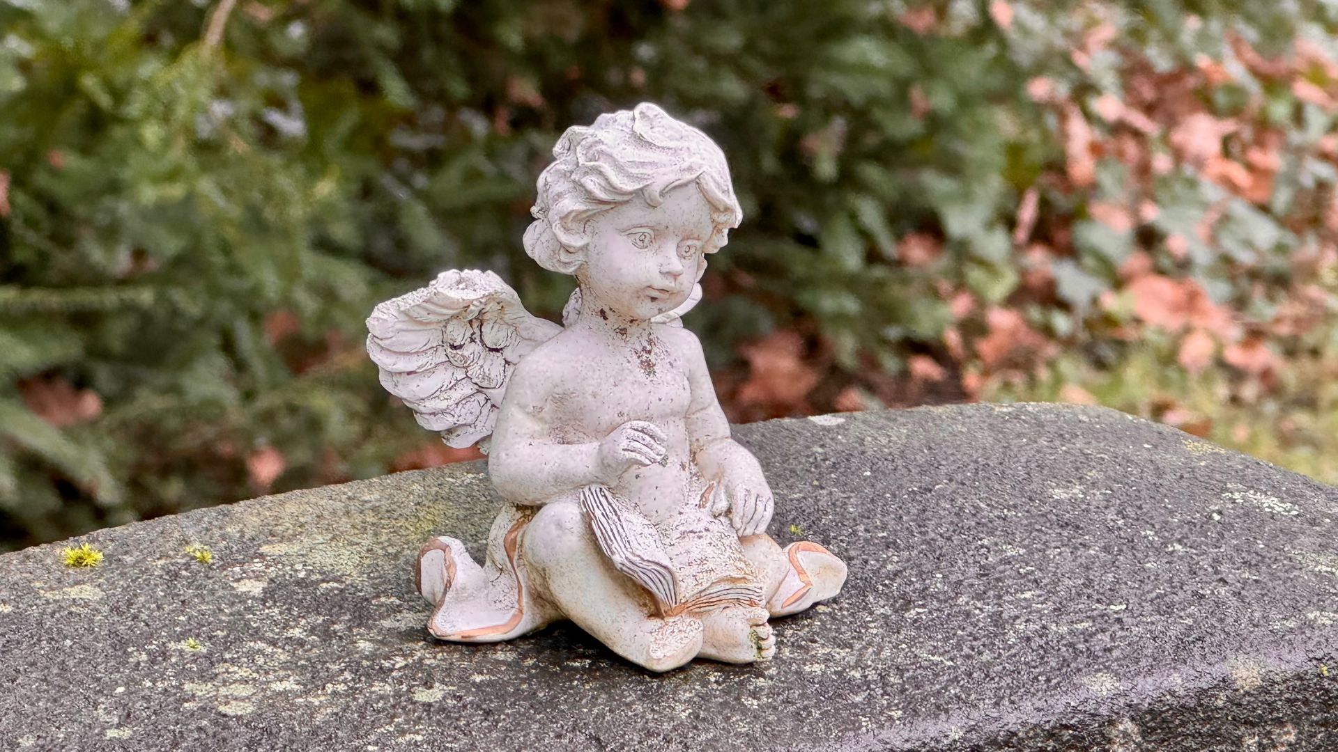 Person im schwarzen Anzug hält eine weiße Urne neben weißen Lilien