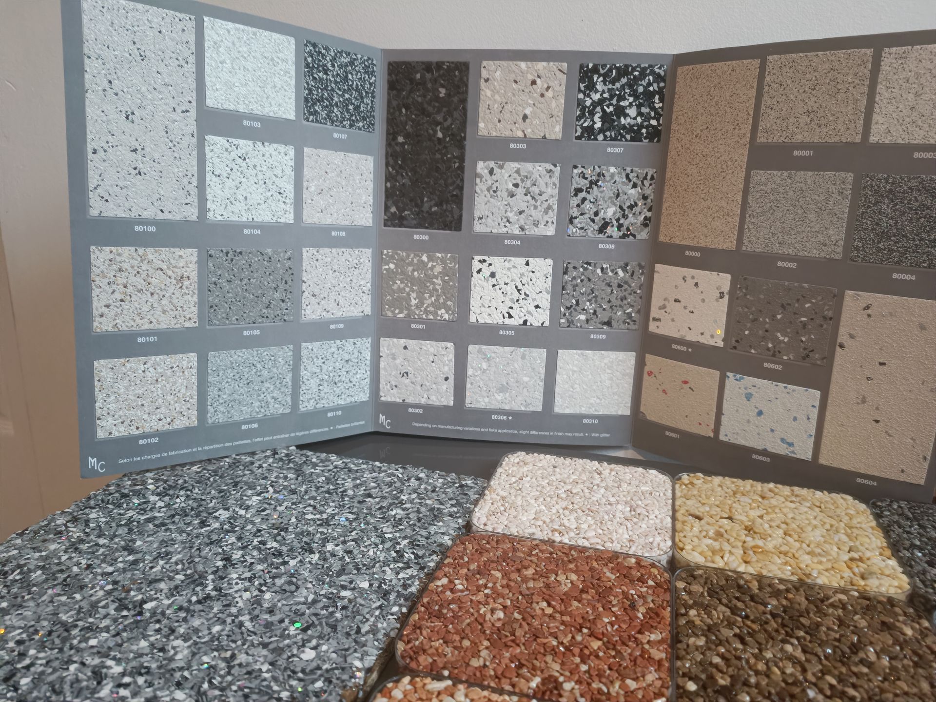 Échantillons et nuanciers de moquette de pierre et résine pailletée avec différents coloris de granulats