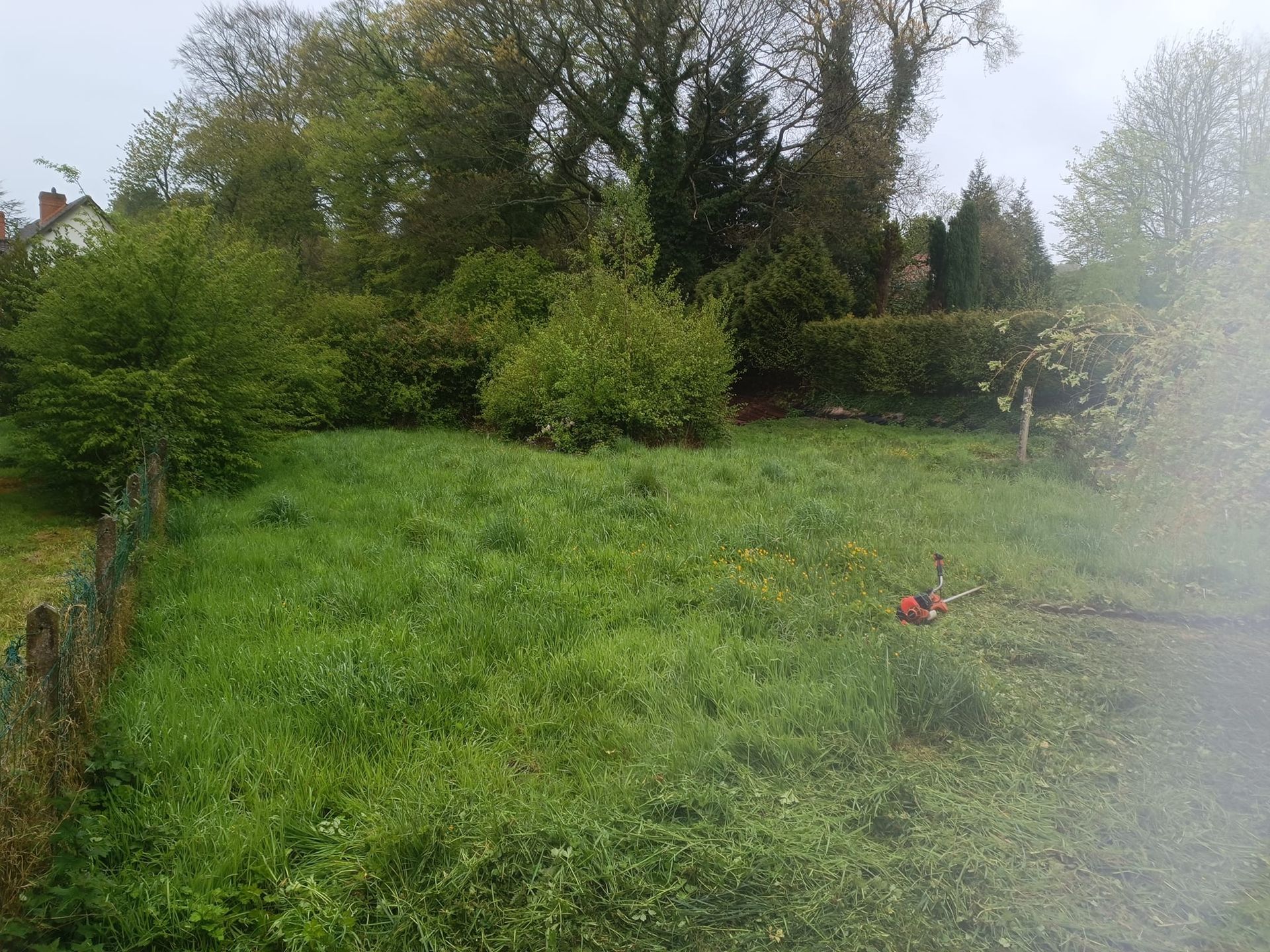 Une terrasse en pierre grise attenante à une maison avec de grandes ouvertures vitrées