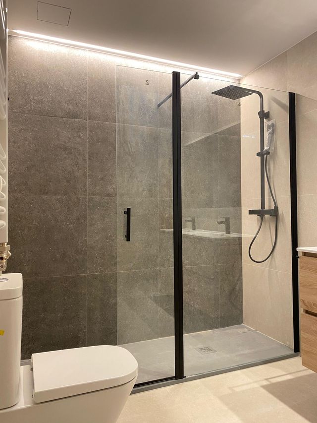 Un baño con ducha, inodoro y lavabo.