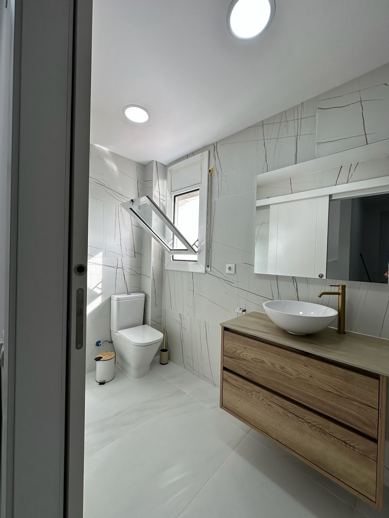 Un baño con inodoro, lavabo y espejo.
