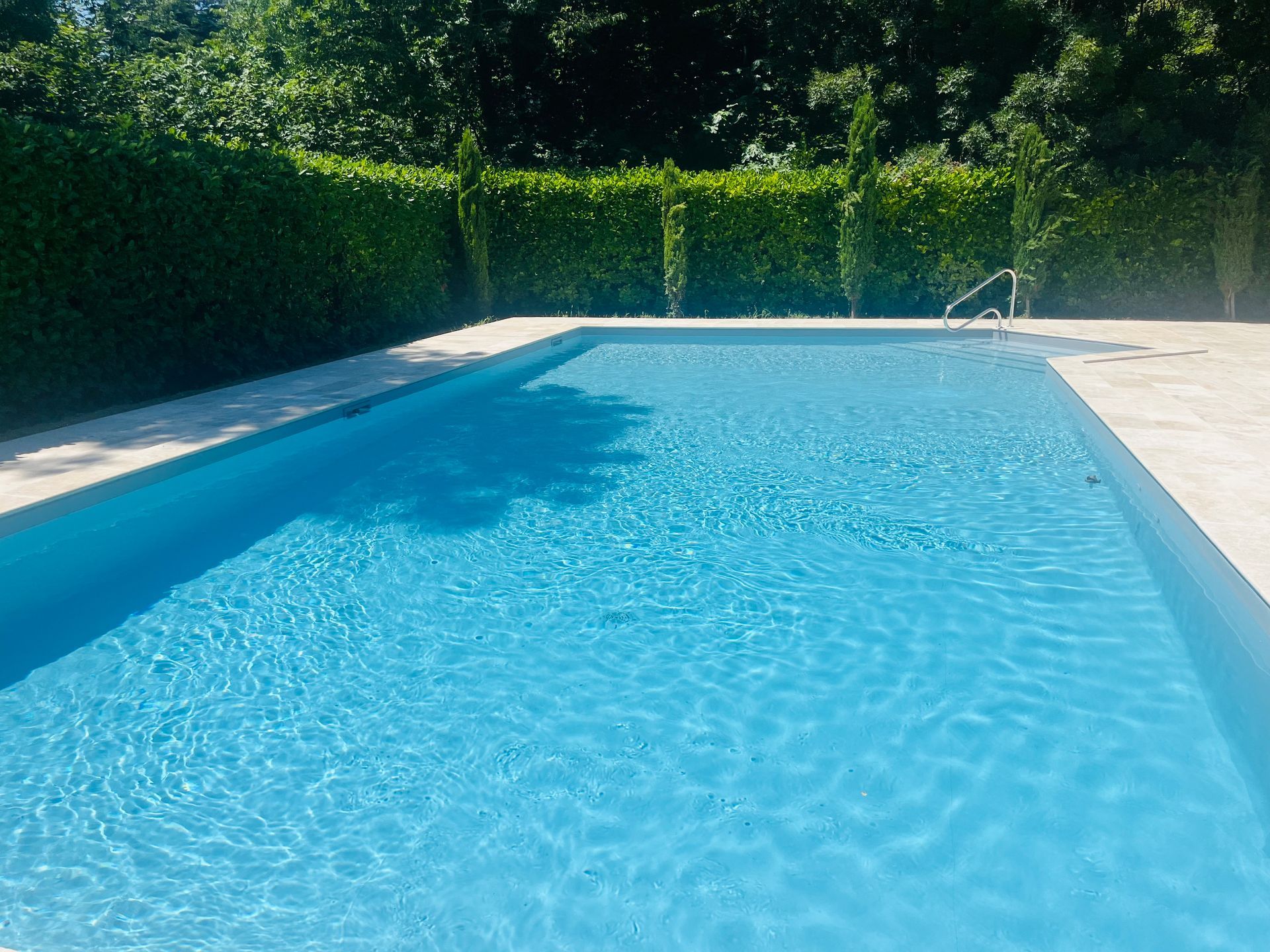 Rénovation de piscine collective avec une plage en travertins et pose PVC armé