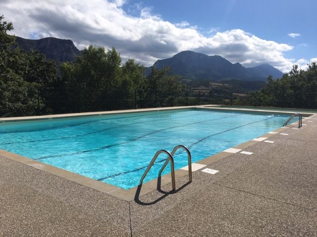 Piscine avec vue sur les montagnes par une journée ensoleillée.