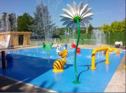 Parc aquatique avec des jets d'eau en forme de fleurs et d'animaux qui arrosent une piscine bleue.