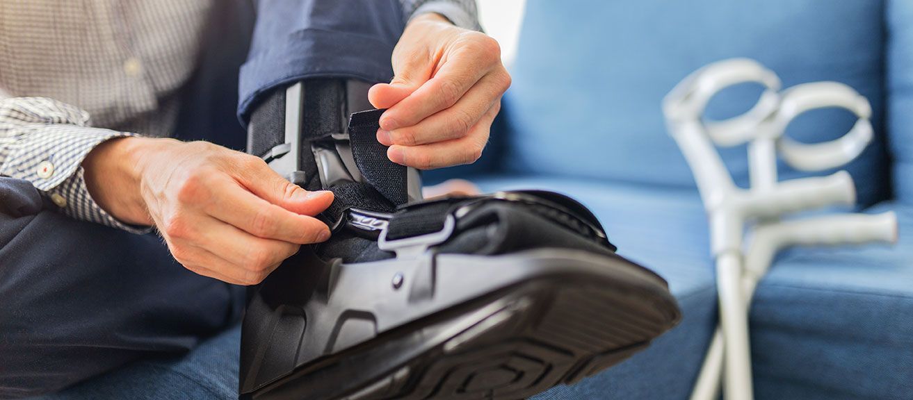 Homme qui enfile une orthèse à son pied