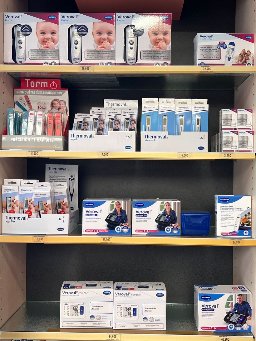 Rayon du magasin rempli de produits de beauté et de soins personnels en boîte, dans des emballages roses, blancs et bleus.