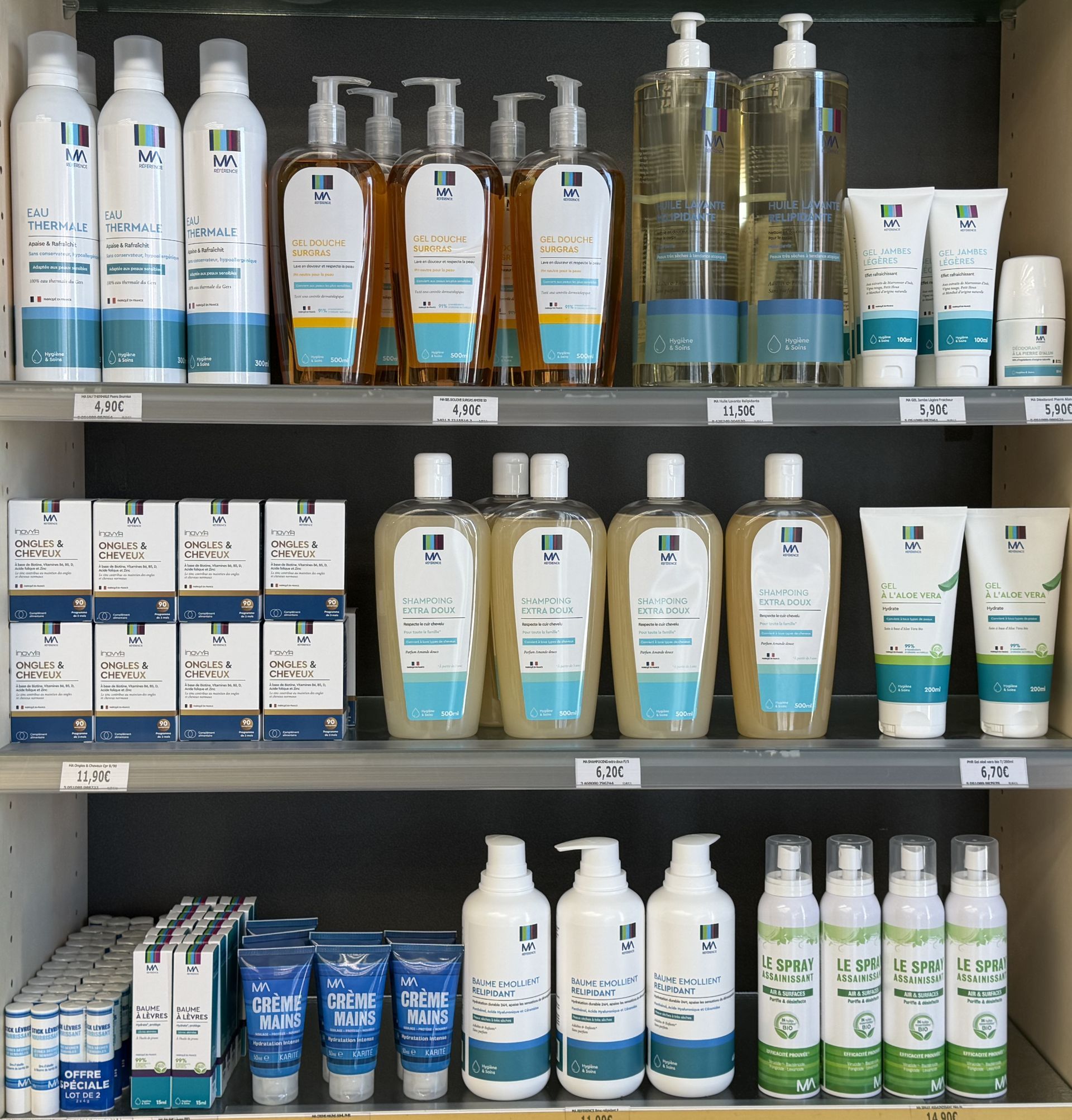 Rayon du magasin garni de flacons, tubes et boîtes de soins capillaires assortis, dans des emballages de plusieurs couleurs.