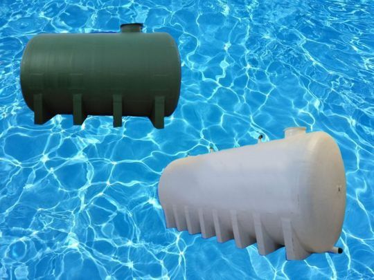 Dos tanques de agua de plástico, verde y blanco, flotando en el agua.