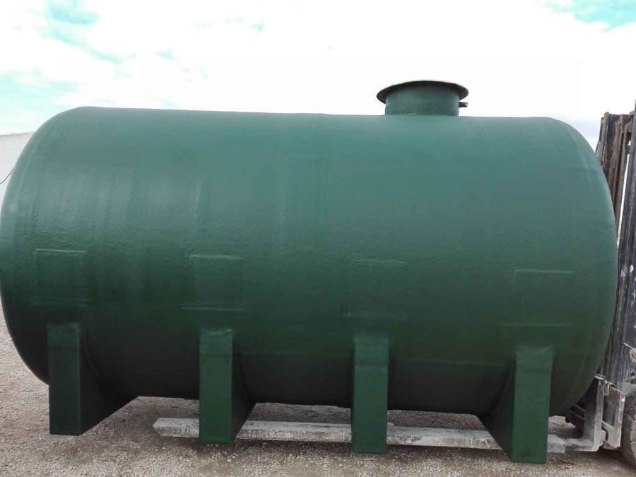 Tanque de almacenamiento horizontal de color verde sobre base de hormigón, probablemente para líquidos.