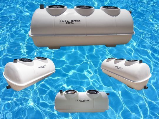 Tanques sépticos blancos, de varios tamaños, flotando sobre un fondo de agua azul.