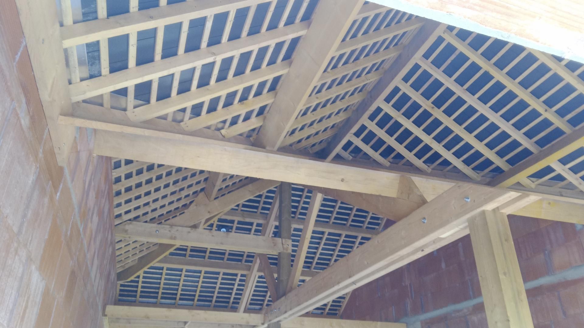 Charpente en bois en cours de construction. Ossature avec chevrons, poutres et isolation.