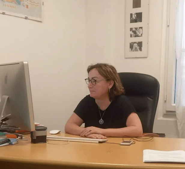 Une avocate est installée à son bureau, devant un ordinateur.