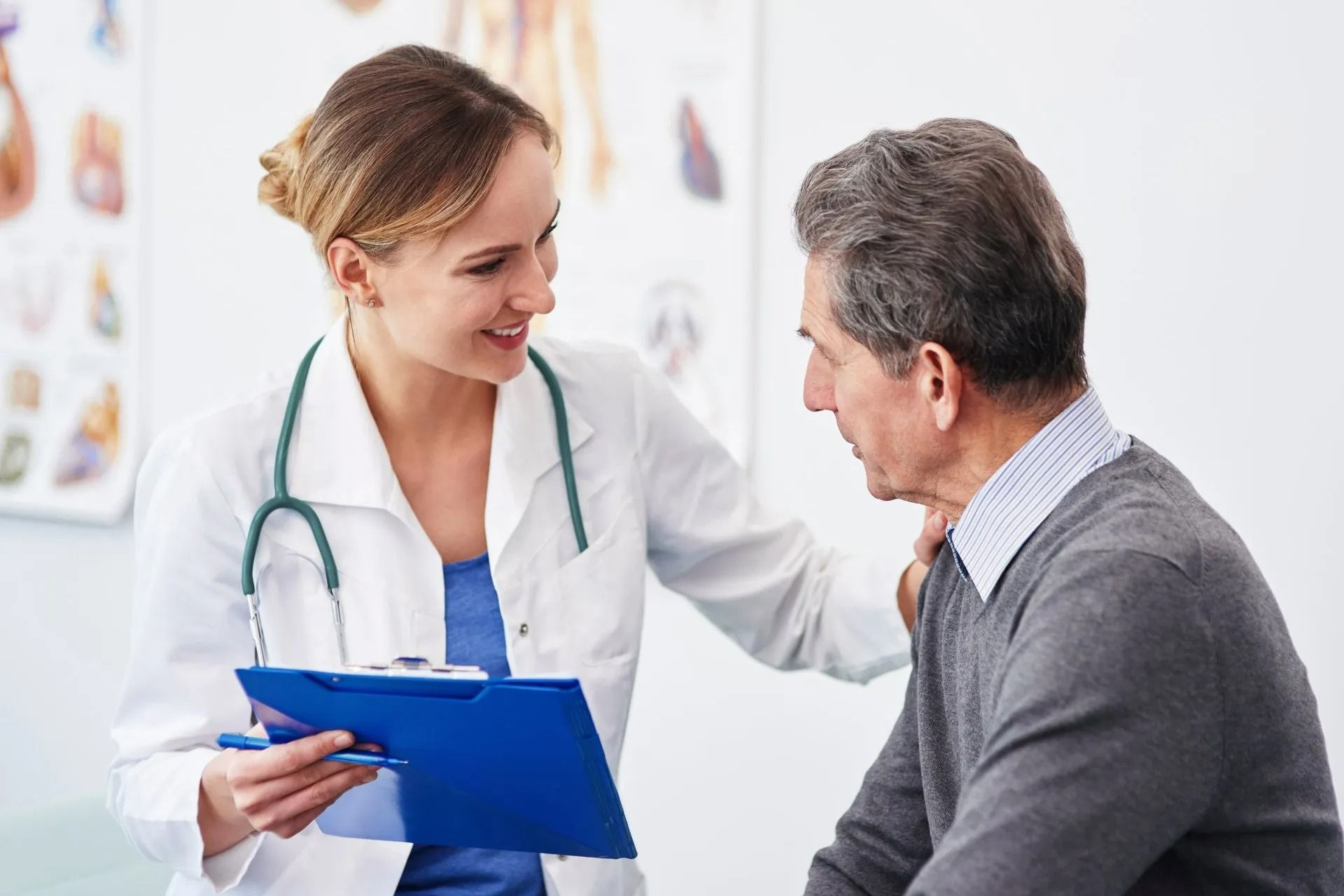 Un médecin consulte un patient, tenant un bloc-notes bleu et souriant dans une clinique.