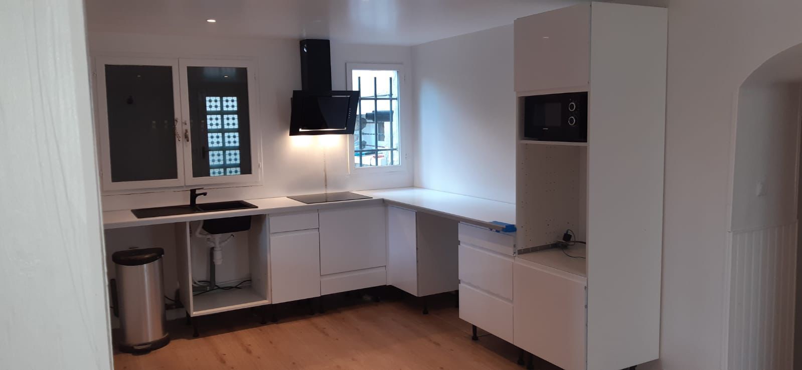 Des outils de construction, une échelle et un casque de chantier dans un espace de bureaux en rénovation.