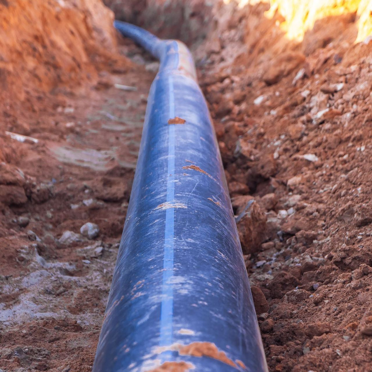 Un tuyau d'assainissement bleu dans la terre