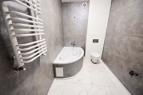 Ein Badezimmer mit Badewanne, Toilette und Handtuchhalter.