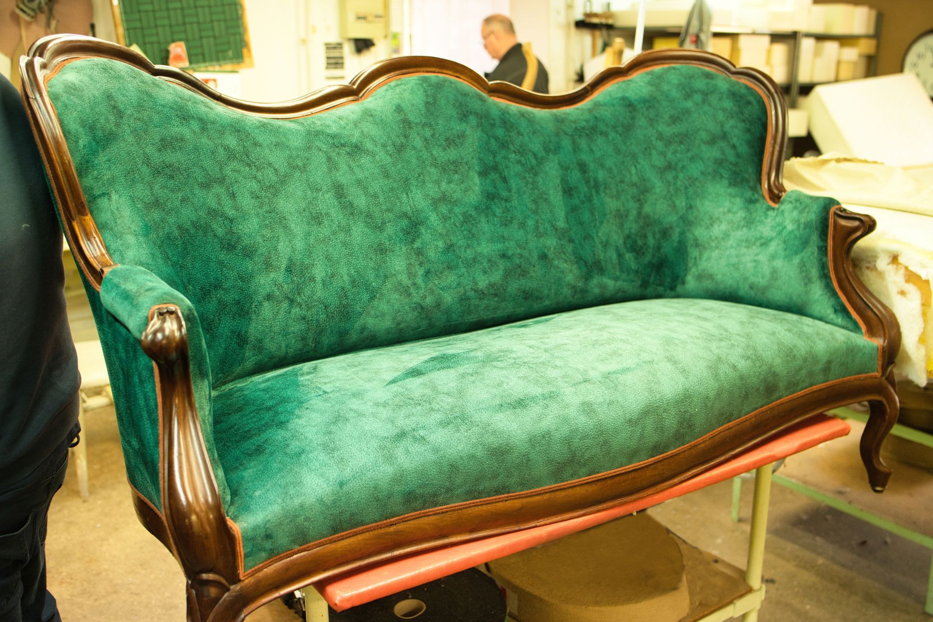 Canapé vert à deux places et armatures bois.