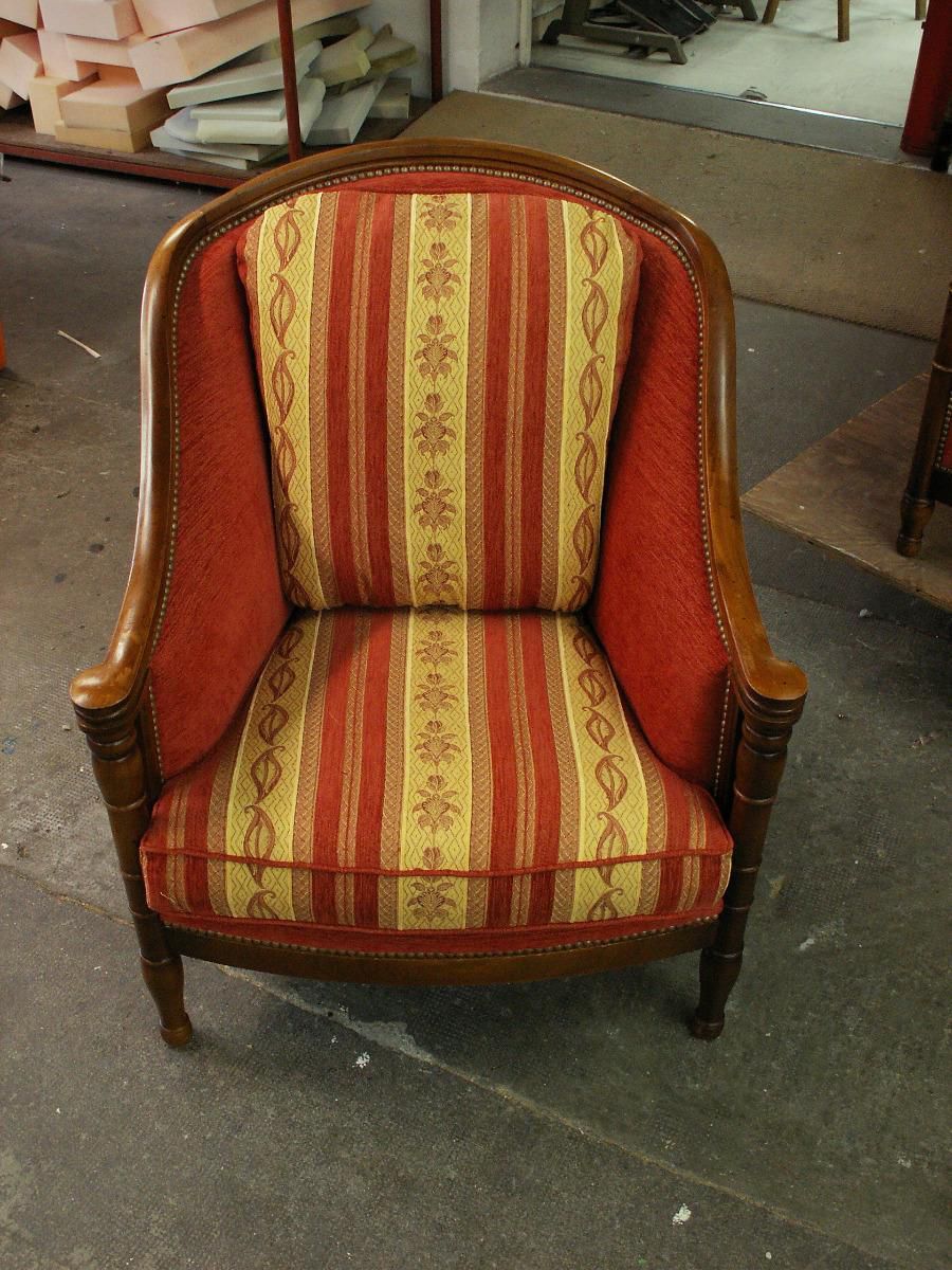 Fauteuil en tissu aux couleurs chaudes avec des petits motifs.