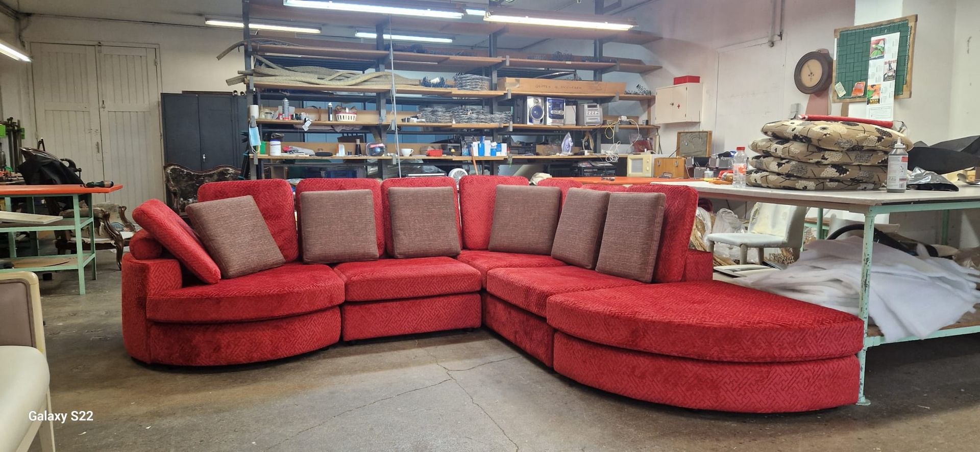 Grand canapé d'angle rouge avec coussins.